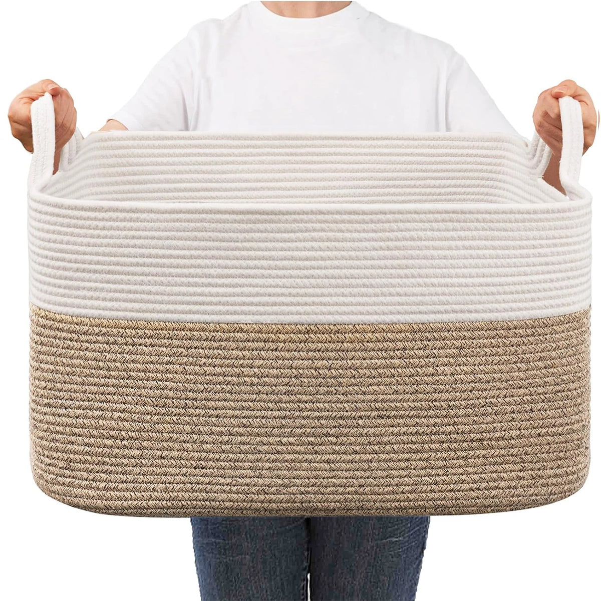 A beige woven cotton rope storage basket with a natural fiber accent band is held by a person.