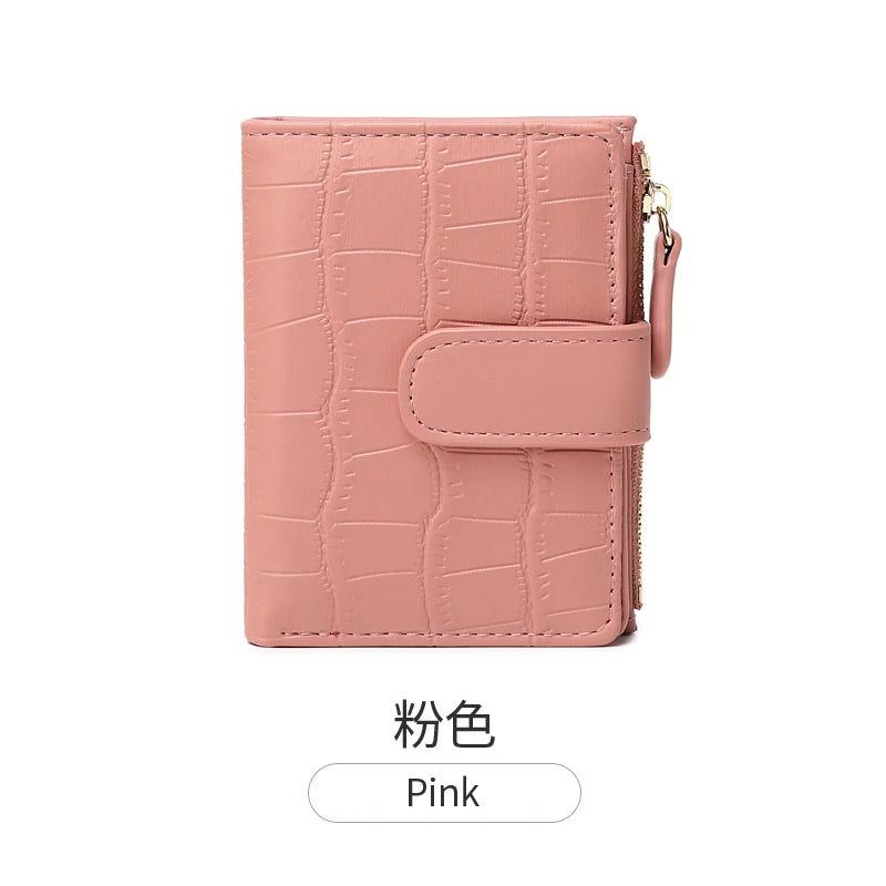 A pink croc-embossed PU leather bifold wallet with a flap and gold hardware.
