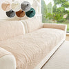 A cream anti-slip sofa cover is displayed with various fabric swatches and a potted plant in a bright room.
