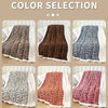 A collection of leopard print plush jacquard throw blankets in various shades and textures displayed on a light wooden surfac