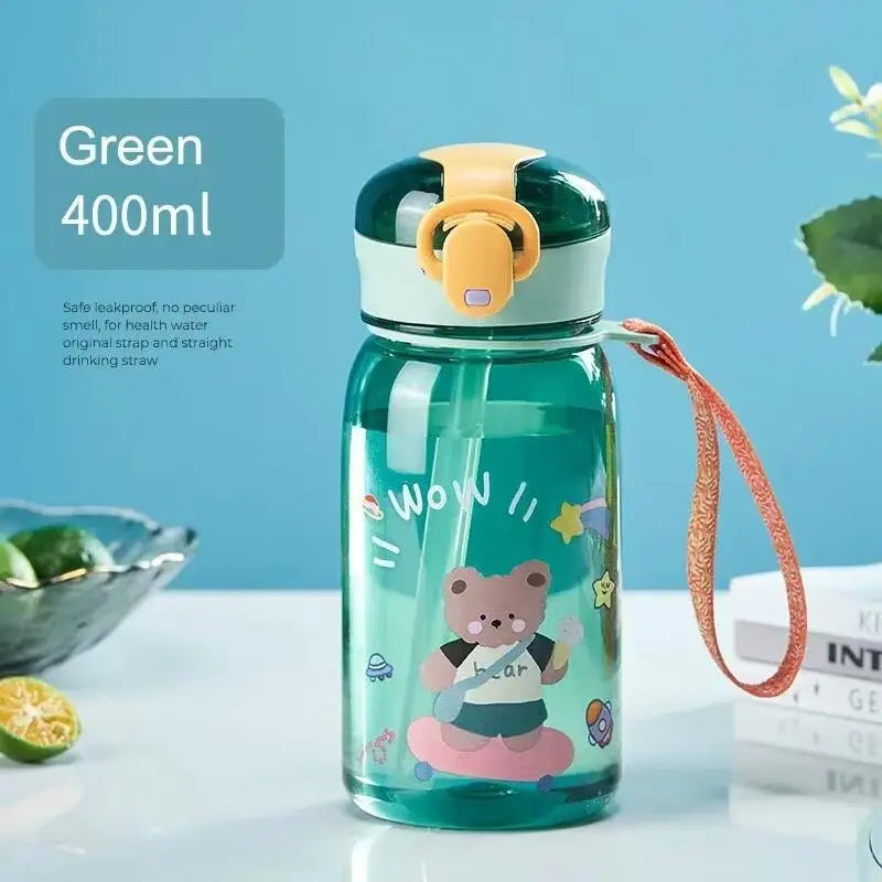 A teal water bottle with a yellow lid featuring a cartoon bear design, sitting on a white surface.