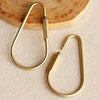 A set of brass gold keychain charms with secure carabiner clips resting on a light surface.