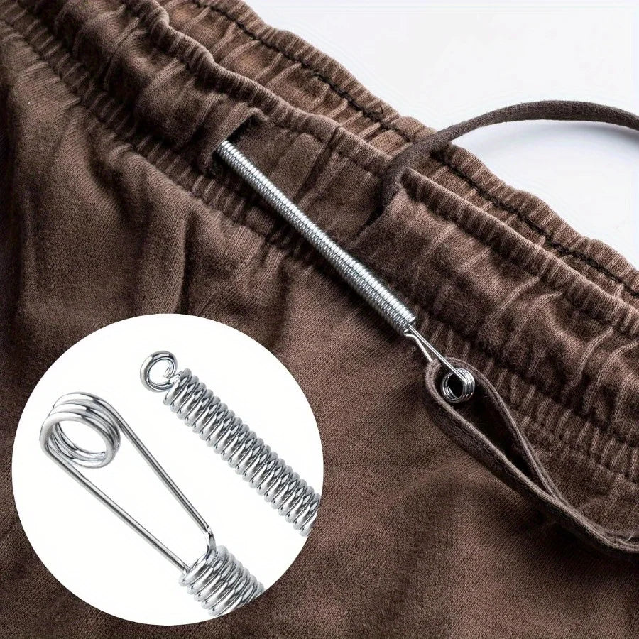 Close-up of a brown fabric drawstring with a silver spring-loaded threader tool.