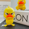 A yellow 3D printed duck statue decoration with an angry expression sitting on a dark surface.