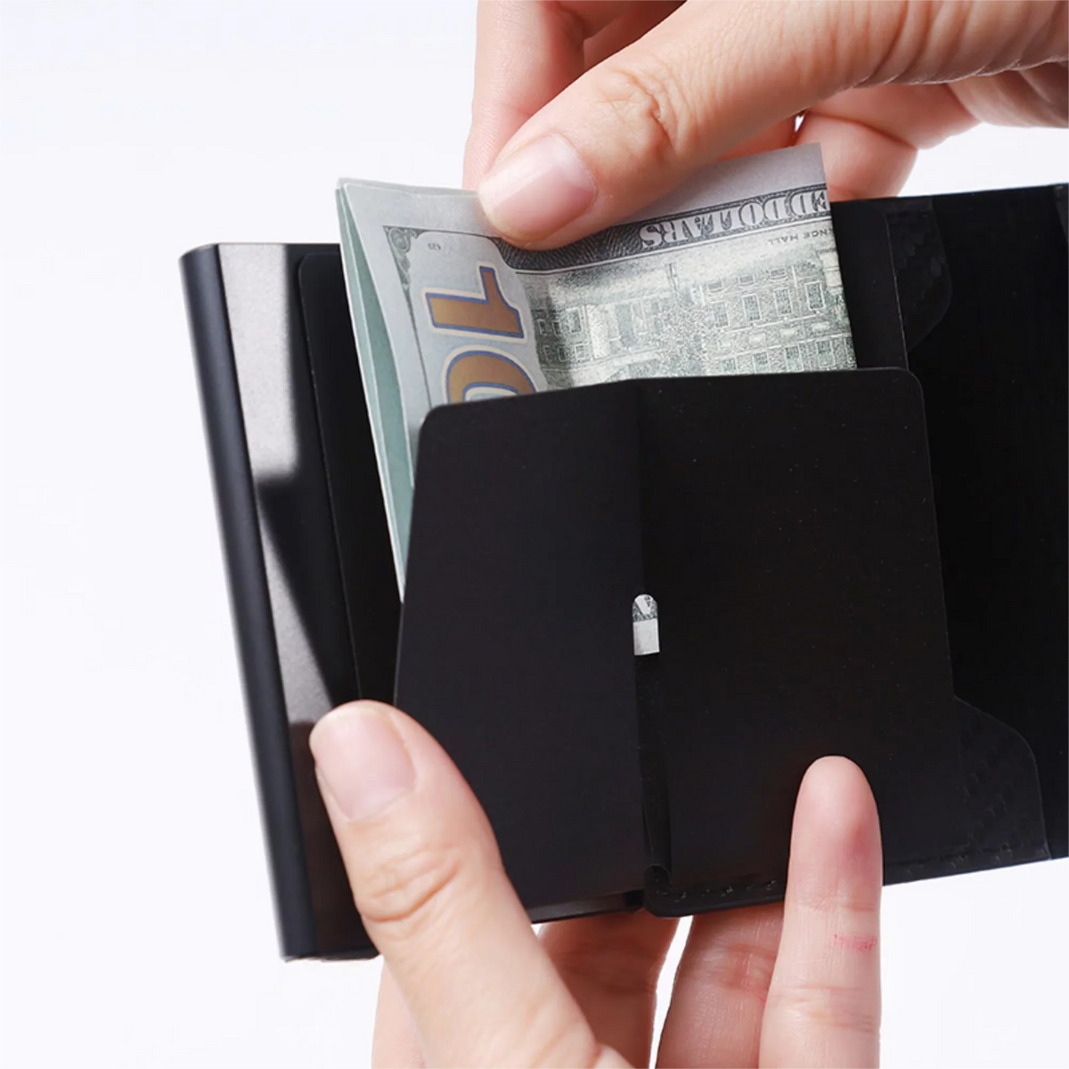 Hands holding a black slim leather card holder with US dollar bills inside.