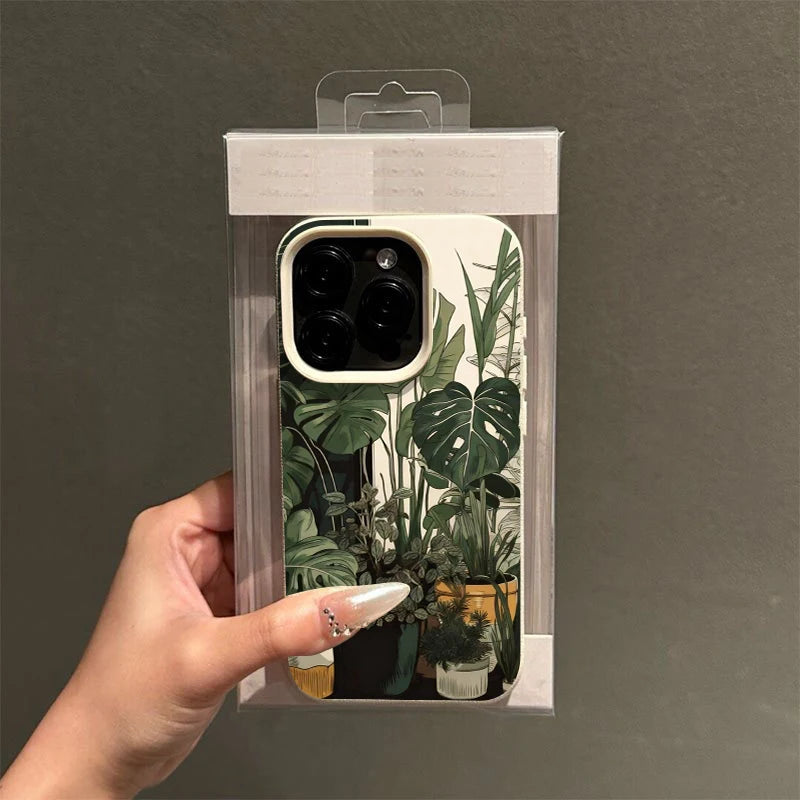 A clear plastic packaging shows a phone case featuring a green monstera plant pattern for an iPhone.