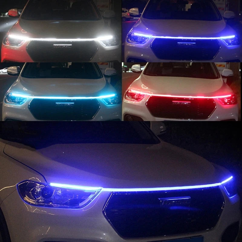 Close-up view of a white car's front grille with blue LED engine hood light strips activated.
