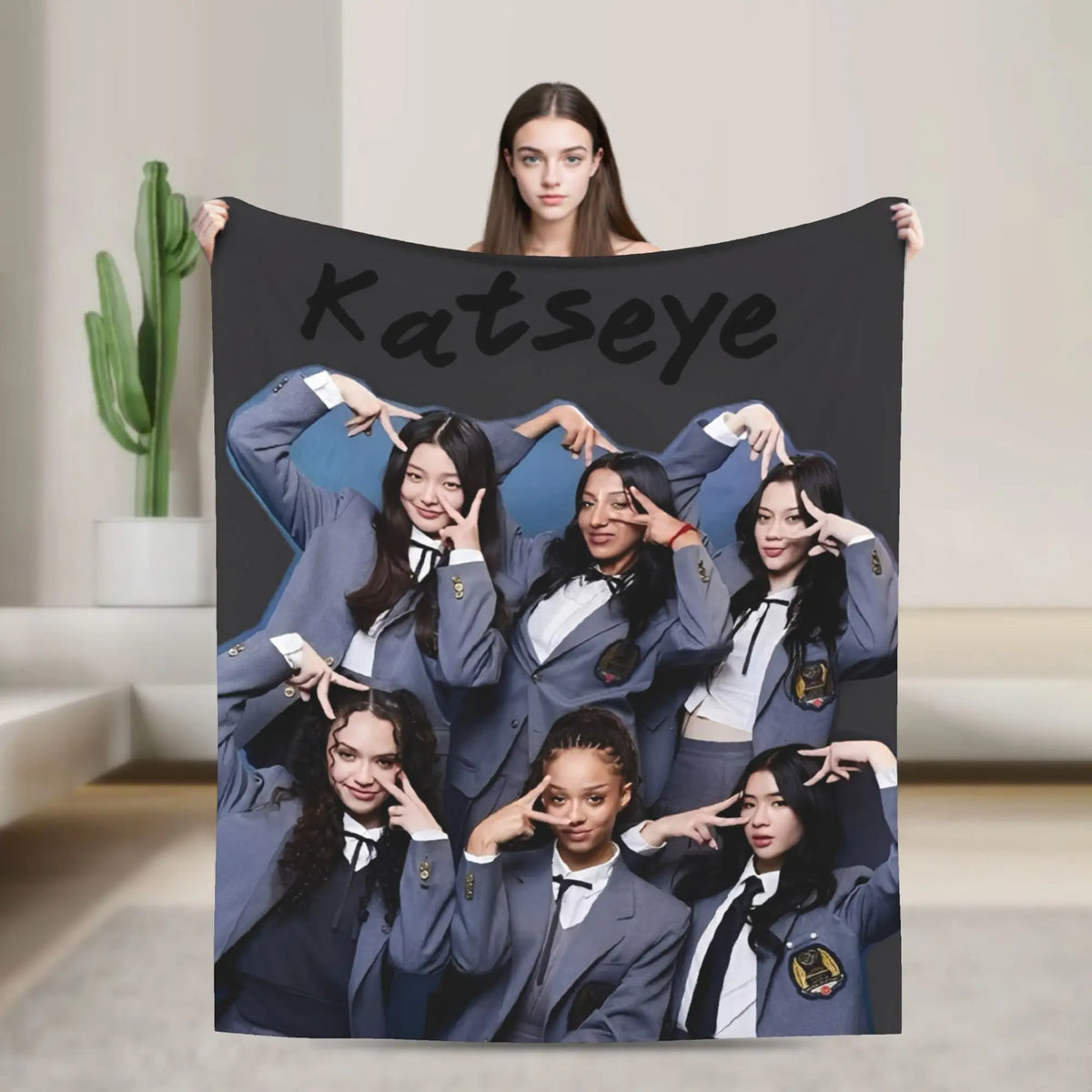 A large black canvas print featuring a group of women with the name Katseye above them.