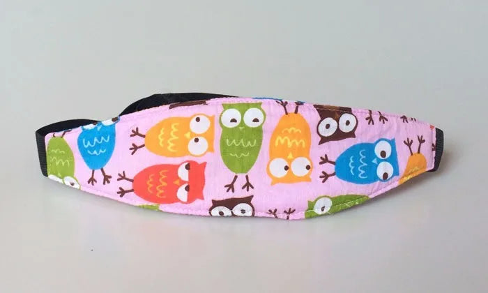 Pink fabric sleeping headrest featuring colorful owl designs for a baby car seat.