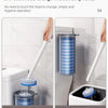 A hand uses a rainbow button to change the head of a disposable toilet brush without touching the seat.