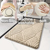 A beige plush velvet bathroom mat with a textured pattern and non-slip backing shown on a floor.