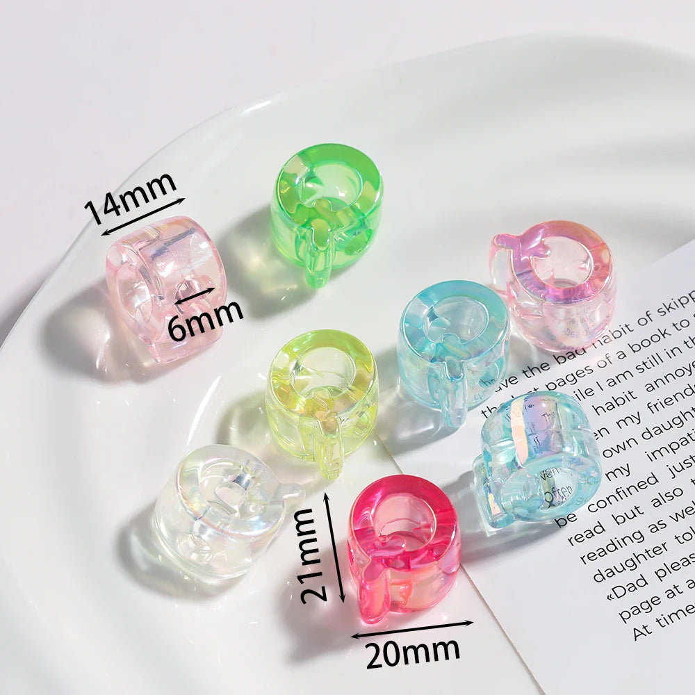 A collection of clear and colored acrylic alphabet beads of various sizes displayed on a white plate.