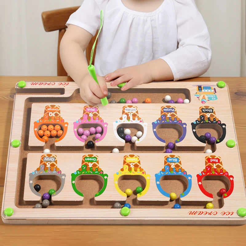 A wooden magnetic color sorting maze board for kids with various colored balls and a child interacting with it.