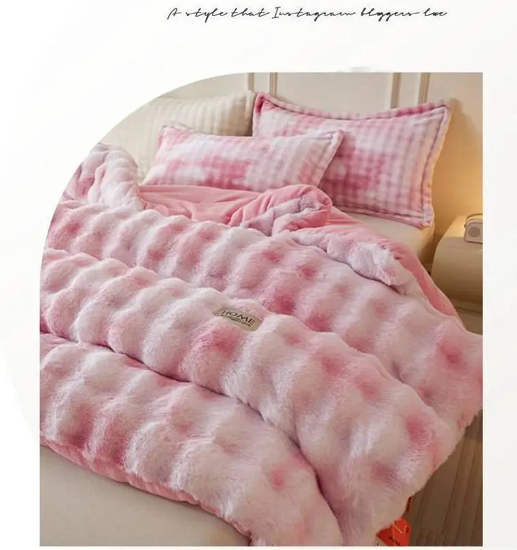 Pink and white checkered plush winter comforter or quilt draped on a bed.