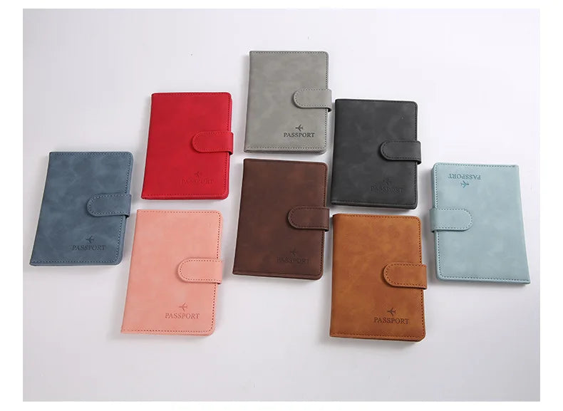 Une collection de porte-passeport en cuir de différentes couleurs : rouge, gris, noir et beige.