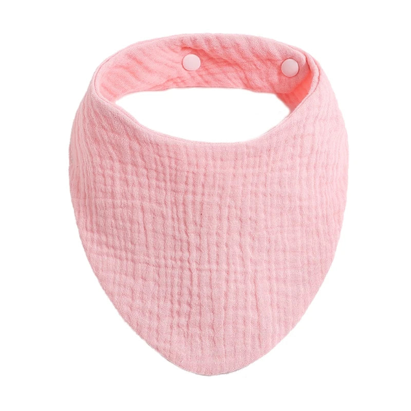 A pink organic cotton muslin baby bib with an absorbent band around the neck.