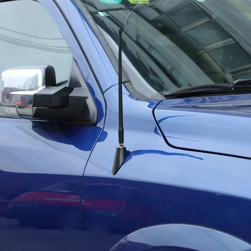 Carbon fiber antenna base cover installed on the side of a blue Dodge RAM 1500 truck.