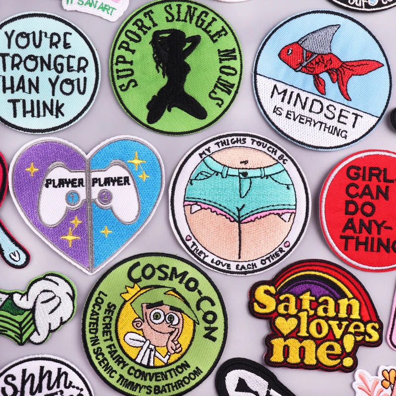 A collection of colorful embroidered iron-on patches featuring various designs and text.