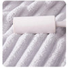 A rolled white microfiber towel resting on a textured gray towel surface.