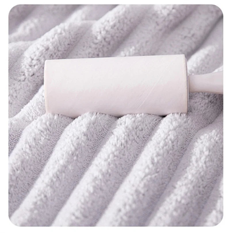 A rolled white microfiber towel resting on a textured gray towel surface.