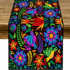 A vibrant floral pattern table runner featuring bright colors like pink, orange, purple, and green on a black background.