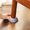 A hand is placing an anti-vibration silicone pad onto the leg of a wooden furniture item.