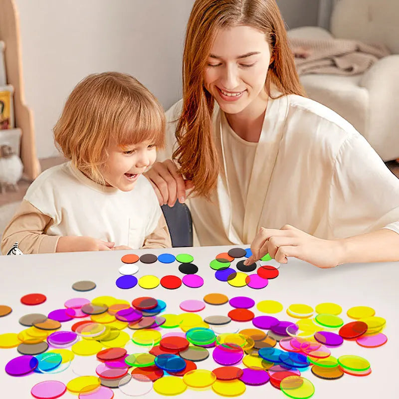 A woman is helping a toddler sort colorful transparent letters and numbers for sensory learning.