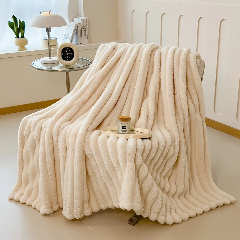 A fluffy cream colored flannel blanket draped over a chair, displayed in a bright room.
