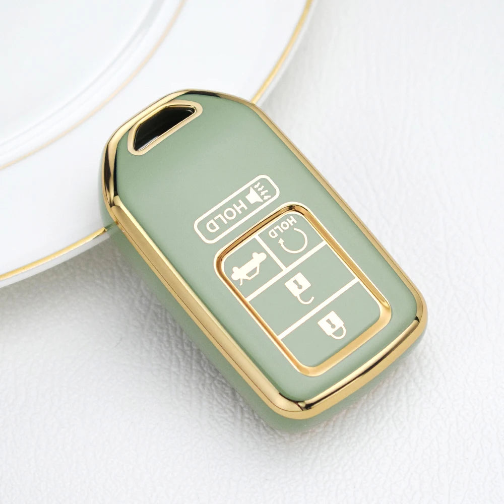 A light green TPU protective key case with gold accents resting on a white surface.