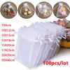 A set of 100 clear organza drawstring gift bags for jewelry and small items in various sizes