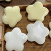 Several soft, squeezable star-shaped stress relief toys in pale yellow and white are displayed in a woven basket.