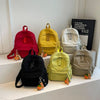 A collection of various colored casual backpacks, including red, yellow, beige, and olive green.