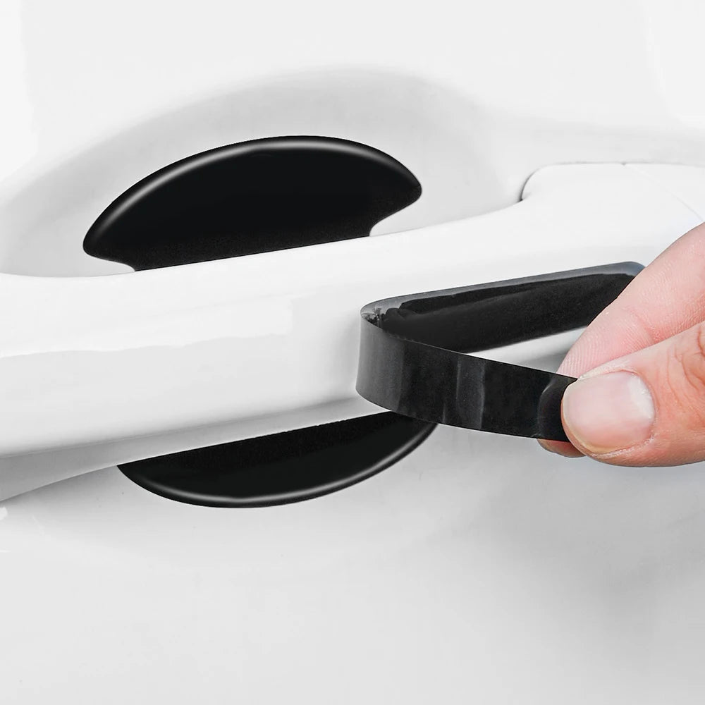 A hand is holding a black scratch-proof protective film product, which is designed for car door handles.