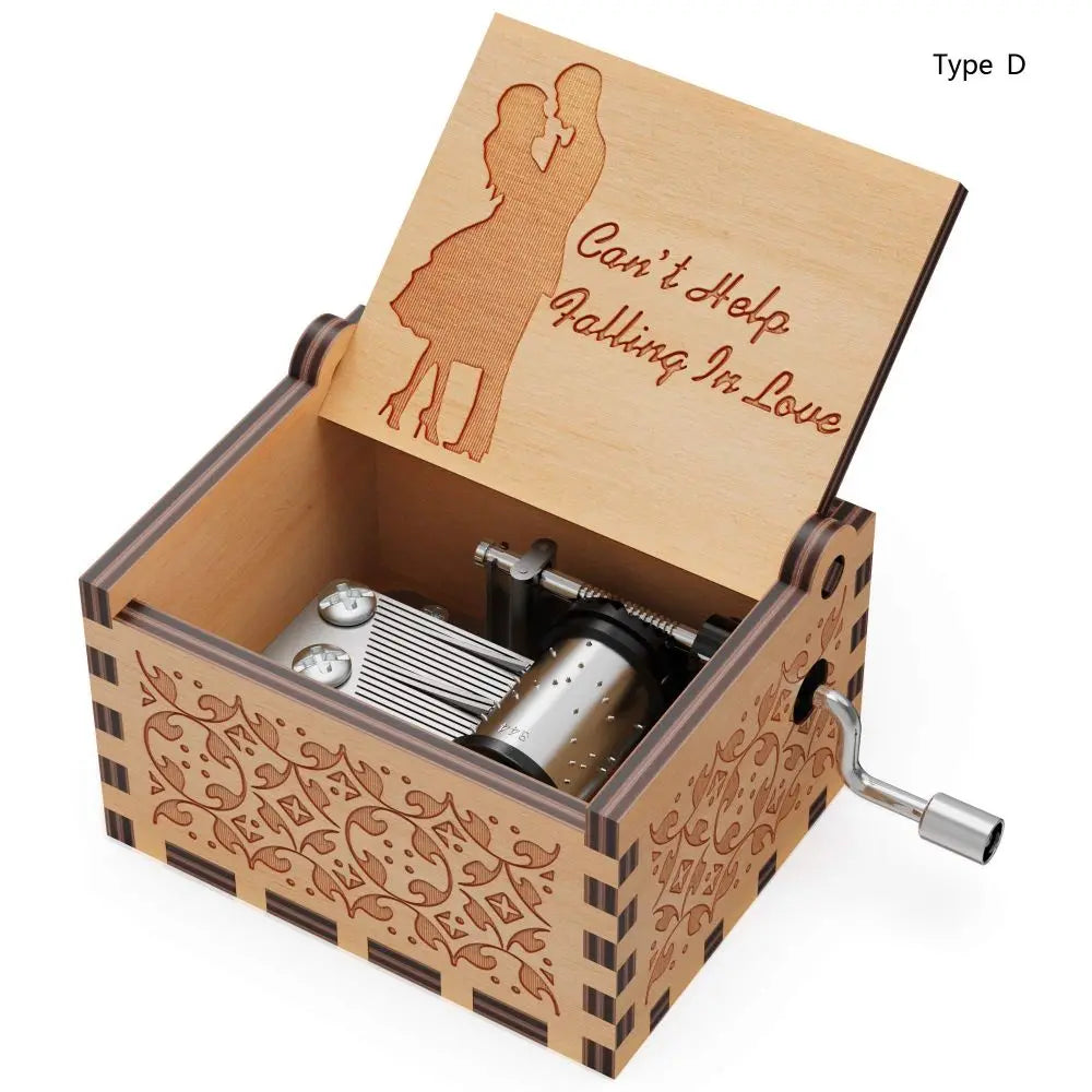 A wooden music box with a lid featuring a silhouette of a couple and decorative carvings, showing the hand-crank mechanism.