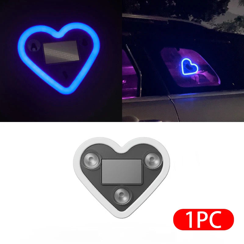 A heart-shaped ambient light featuring a silver rectangle, shown in glowing blue and purple light on a car interior.