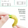 A hand holds a yellow silicone fruit-shaped baby rattle teether, demonstrating its soft and elastic texture.