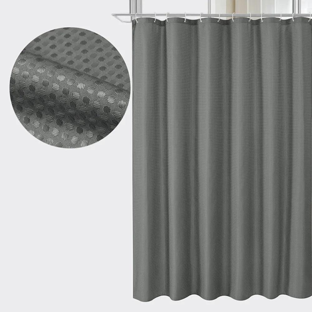 Gray waffle textured waterproof shower curtain hanging from a rod
