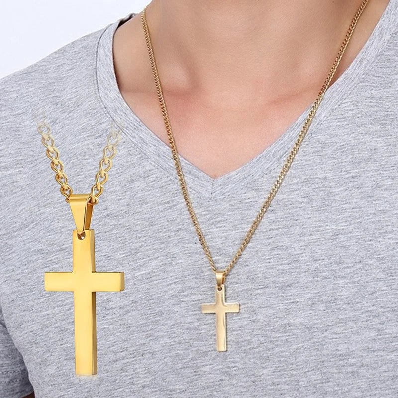 A gold stainless steel cross pendant necklace is displayed against a gray shirt.