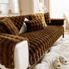 Braunes Plüschkaninchen-Sofa-Kissen über einem weißen Sofa, auf einem flauschigen cremefarbenen Teppich.