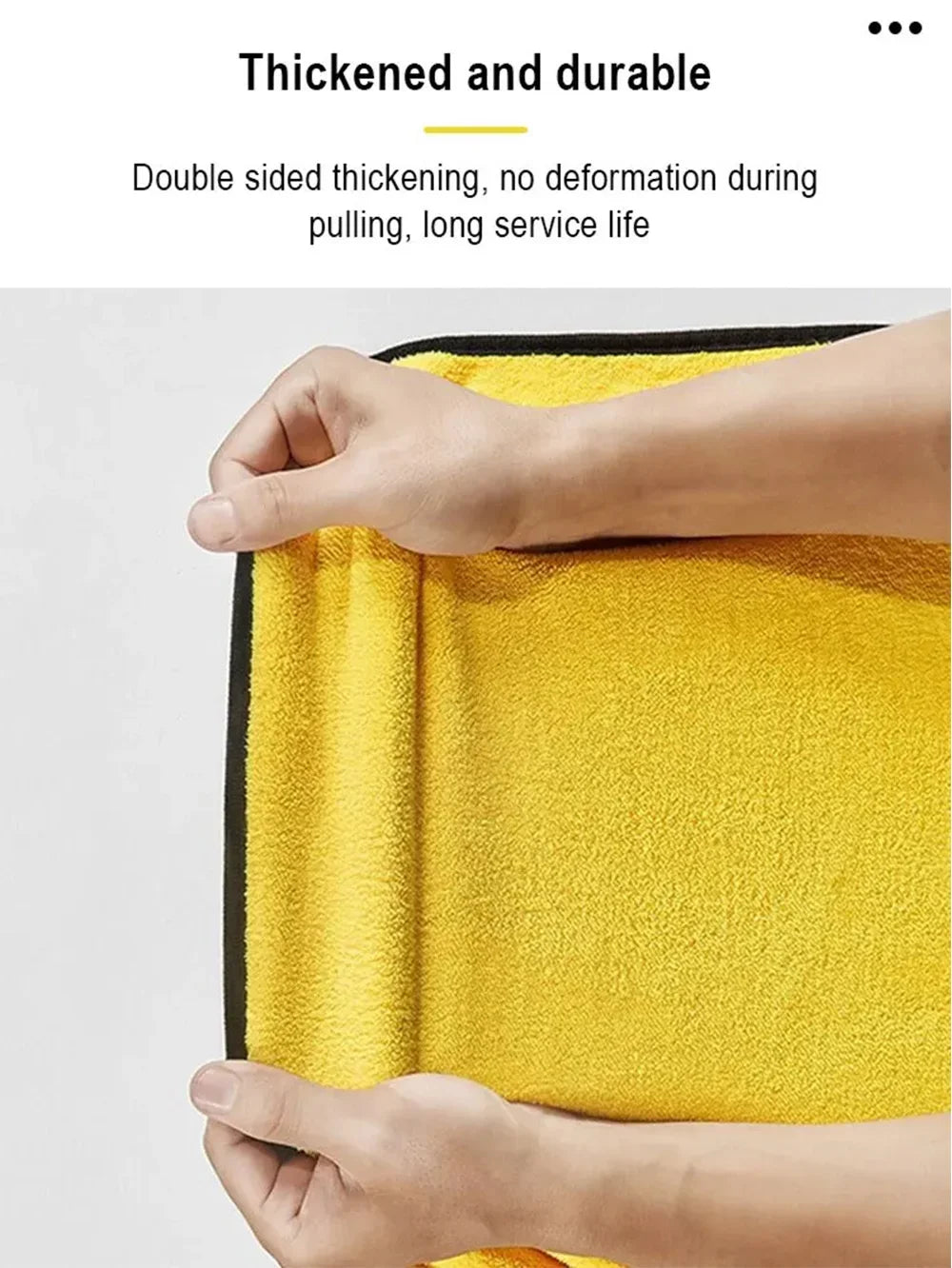 Hands holding a yellow microfiber car cleaning towel showing its thickness and durability.