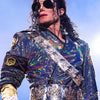 A person wearing a sparkly blue and purple sequined jacket with silver accents and dark sunglasses.