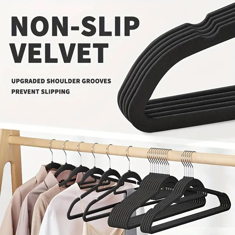 Black velvet non-slip hangers with upgraded shoulder grooves shown hanging on a wooden rod.