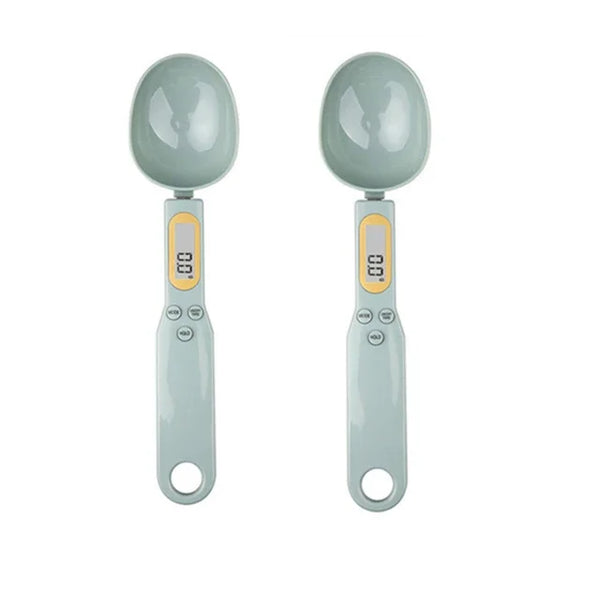 A pair of light gray digital measuring spoons with oval bowls and LCD displays.