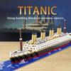 A detailed model kit of the Titanic ship built from building blocks on a wooden surface.