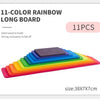 A long board of eleven colored rainbow wooden blocks stacked in a gradient formation.