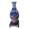 A ceramic vase painted with blue and purple tones featuring a vibrant red bird design.