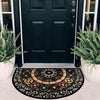 A vintage stone tile doormat with a geometric pattern placed on a light-colored doorstep.