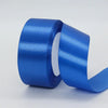 A roll of bright blue satin ribbon used for gift wrapping or DIY crafts.