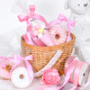 Pink satin ribbon rolls and a wooden basket filled with pink and yellow candies