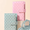 A pink and mint green polka dot PU leather binder wallet with cash envelopes and card holder displayed on a light background.